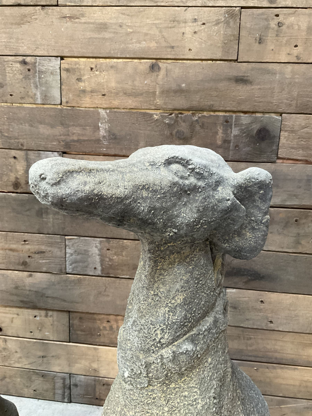 Pair of cast stone French lurchers, seated pose, on shaped plinth